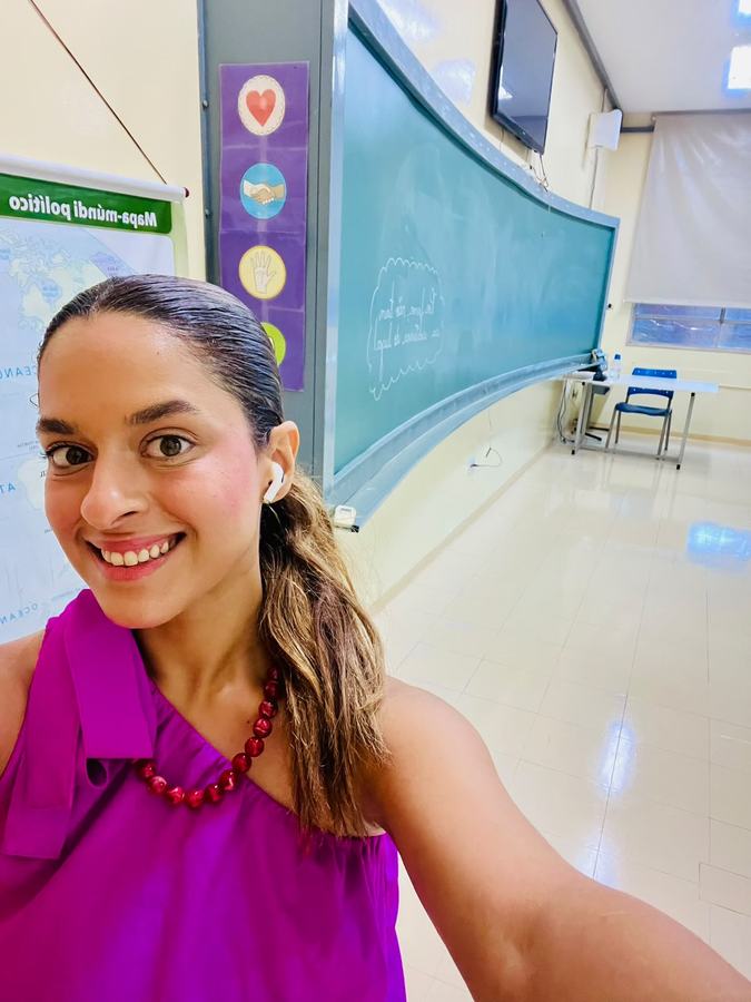 Beatriz in an empty classroom before class